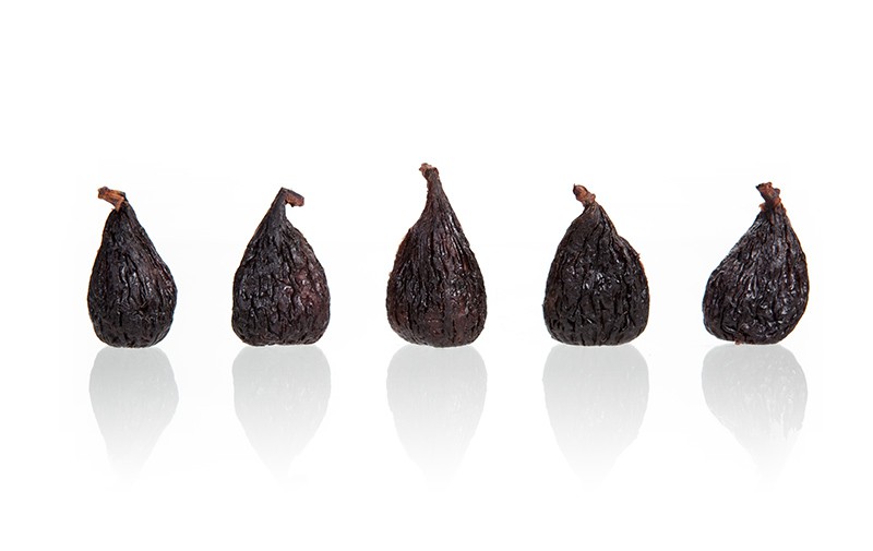 A row of five figs stands in front of a blank, minimalist background.
