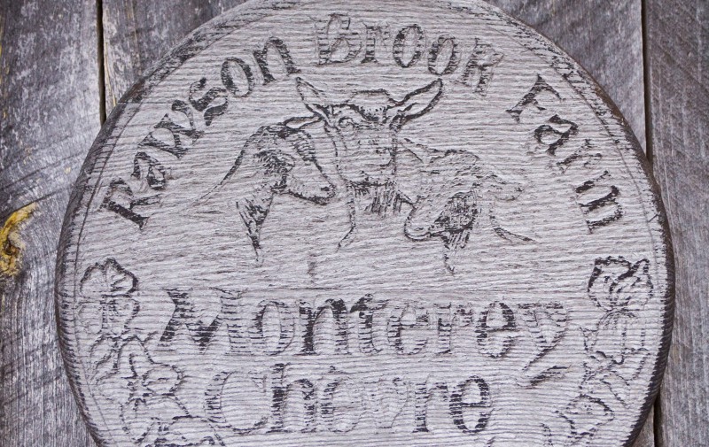 A weathered wooden sign displaying the name of the operation